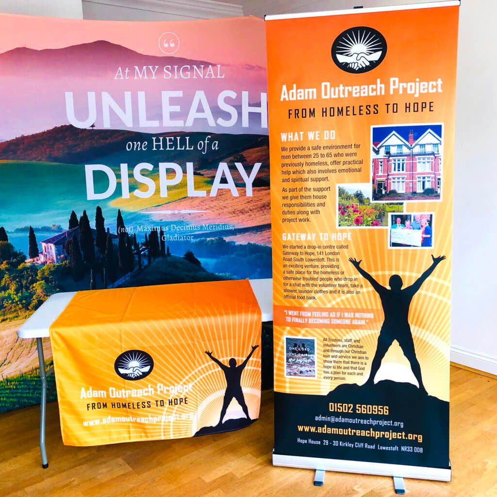 Photograph of branded roller banner and table runner for Adam Outreach Project